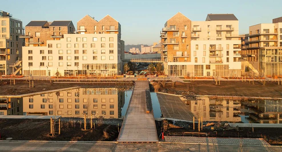 Les immeubles de Gaïa au soleil couchant, reflétés dans le bassin