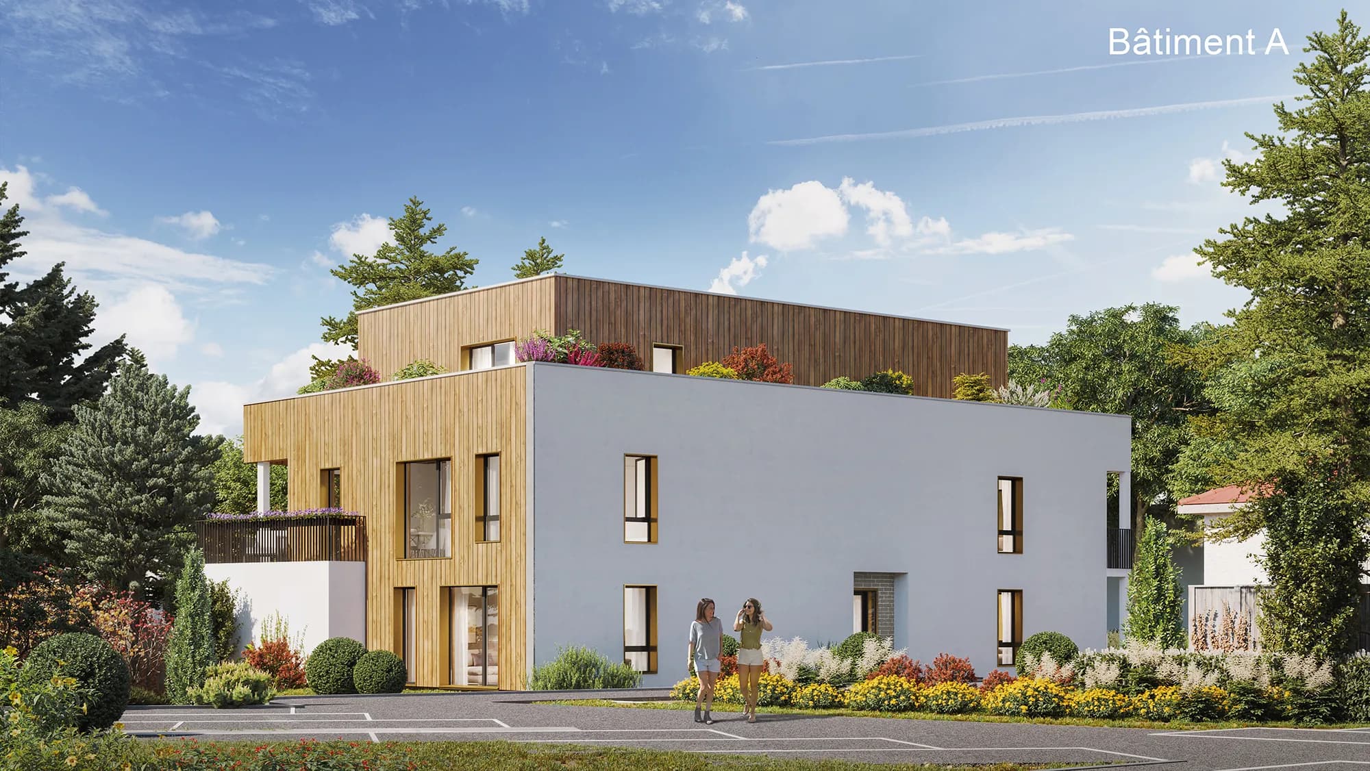 Bâtiment A de Ham’O : deux niveaux à toiture-terrasse, bardage bois clair et enduit gris, attique planté d’arbustes, massifs fleuris et stationnement au premier plan
