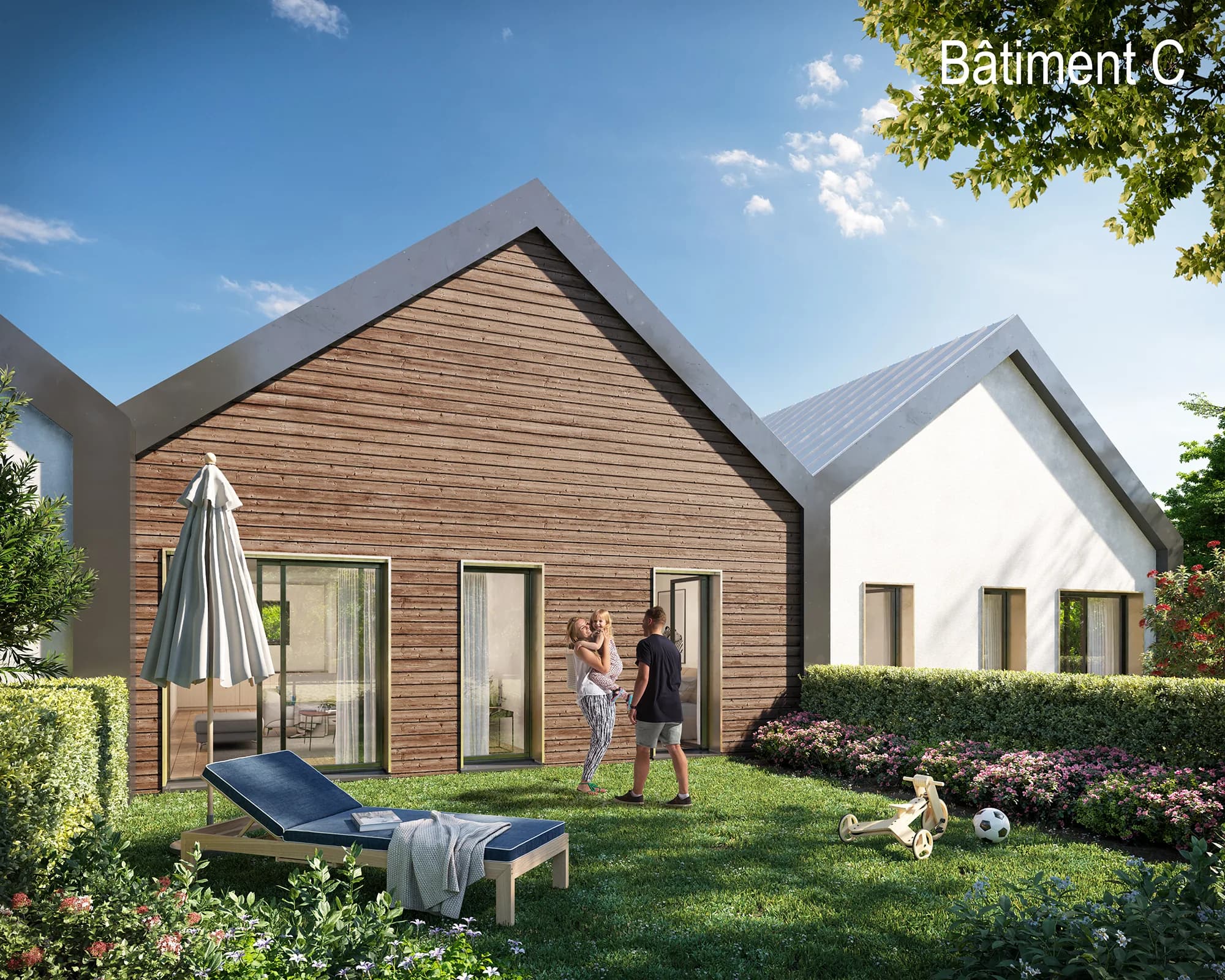 Bâtiment C vu du jardin : pignon en bardage bois horizontal, larges baies vitrées ouvrant de plain-pied sur la pelouse, haies taillées et massifs fleuris