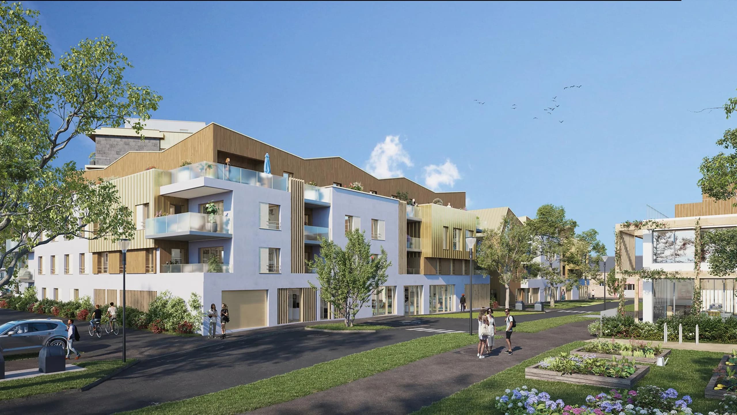 Rue intérieure du Domaine : façades blanches et bardage bois, balcons plantés, commerces en rez-de-chaussée, pelouse et carrés potagers