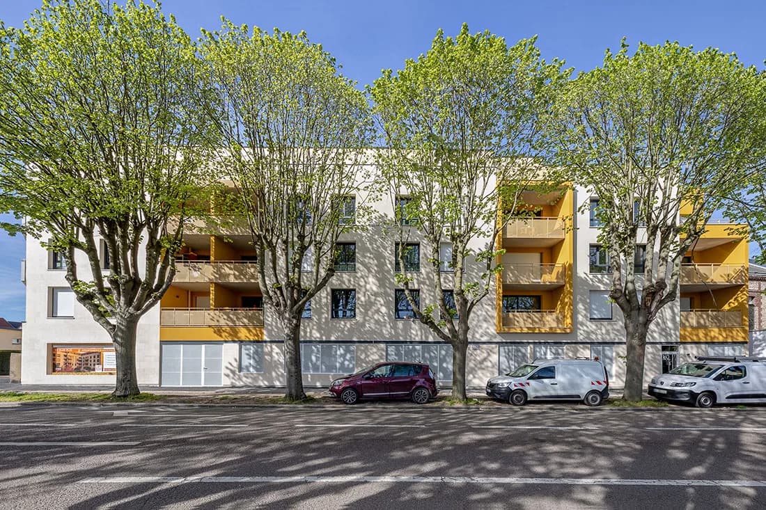 Le Jardin d'Adélaïde à Sotteville-lès-Rouen : façade sur rue bordée de platanes, loggias jaunes