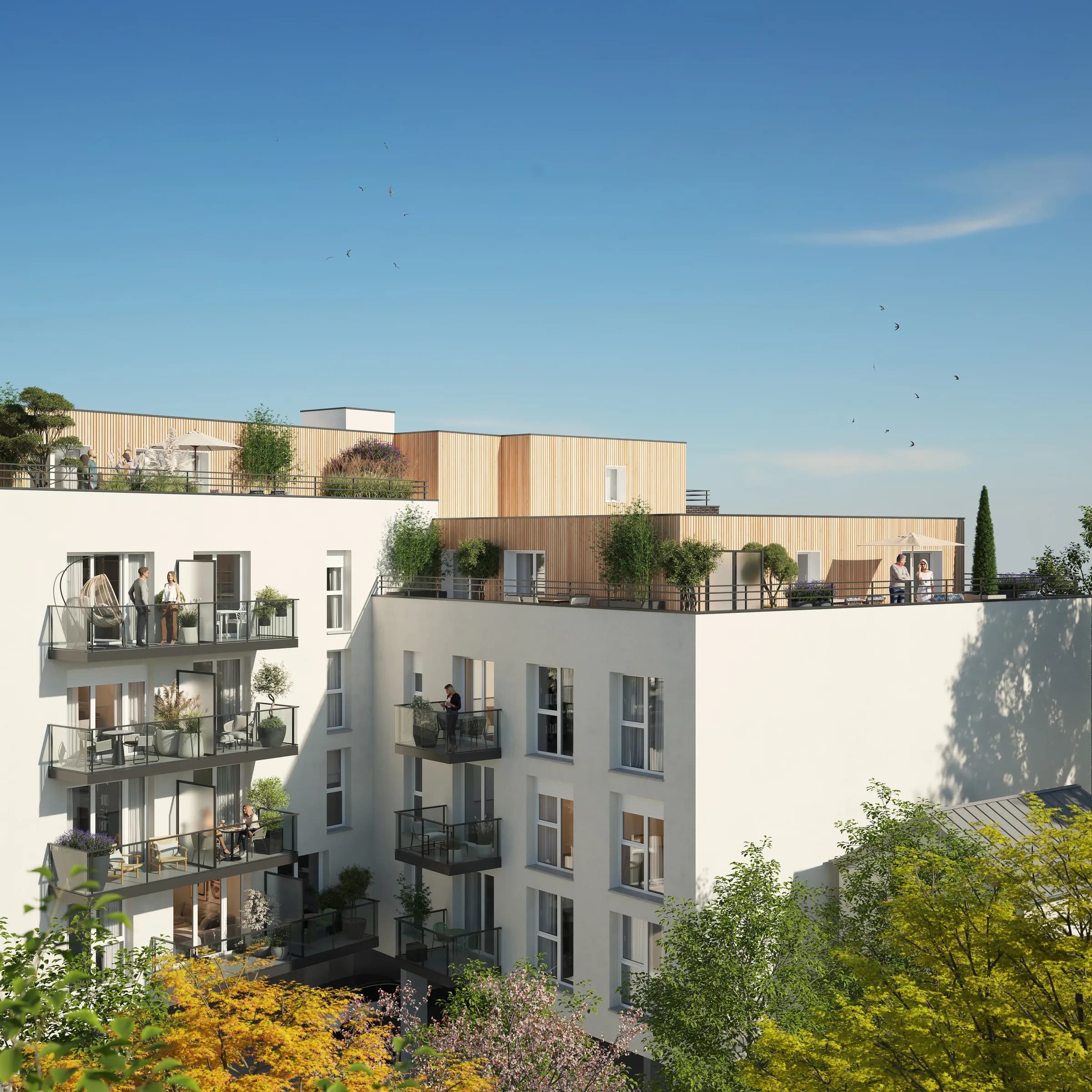 La résidence vue depuis les jardins : balcons en enfilade, terrasses du dernier niveau abritées par un bardage bois, arbres en fleurs au premier plan